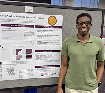 A man standing in front of a poster board. The poster board is displaying information about a research project.