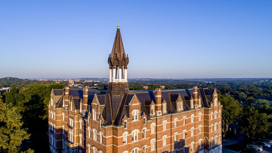 Old, ornate building with clock tower, set against blue sky.