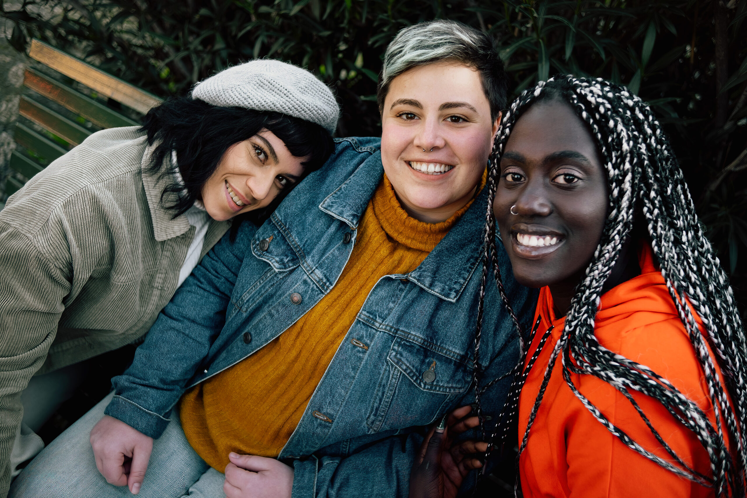 Three people posing for a photo. Two women and a man. They are smiling and appear to be enjoying themselves.