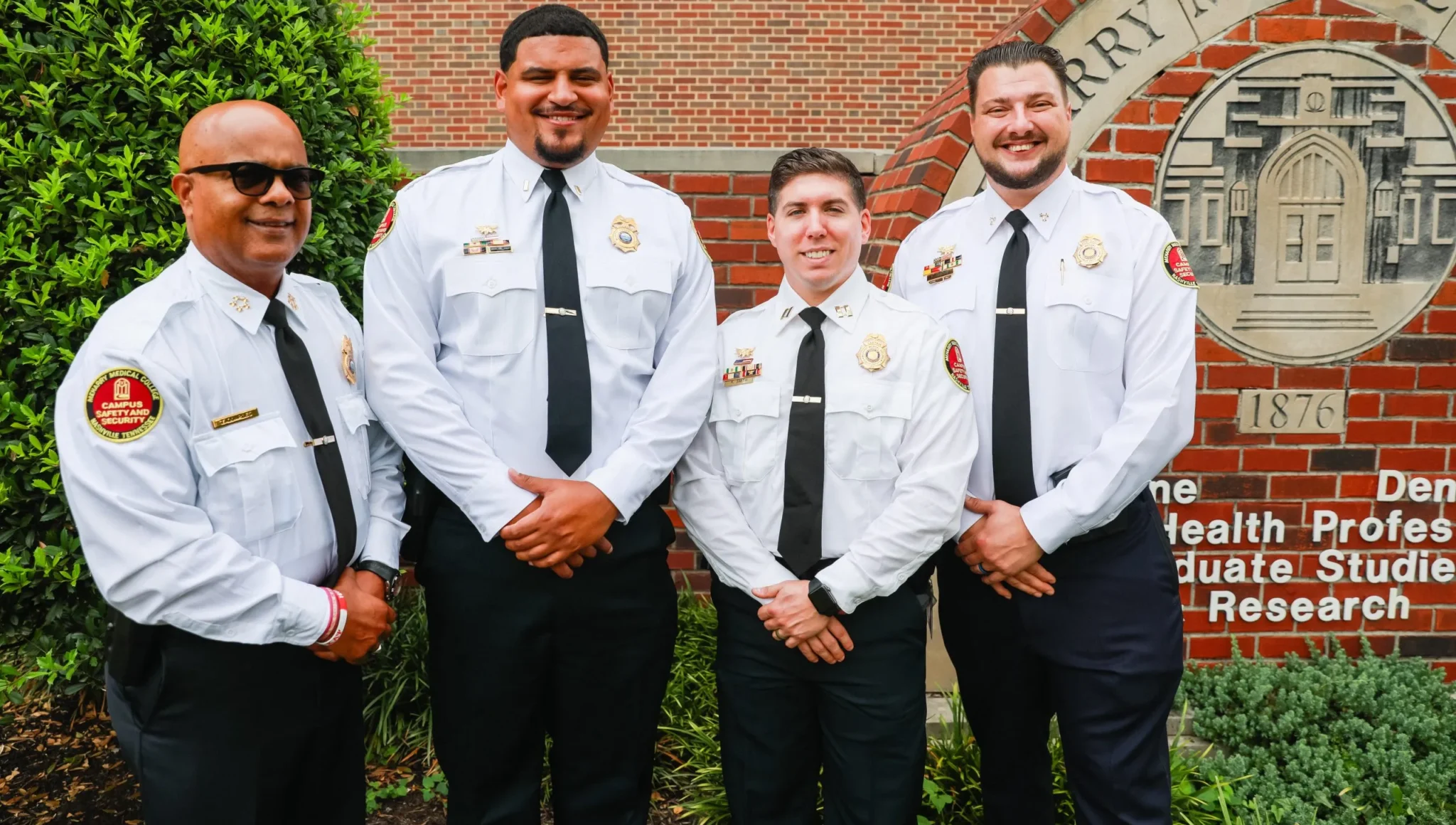 Four police officers standing in front of a sign.