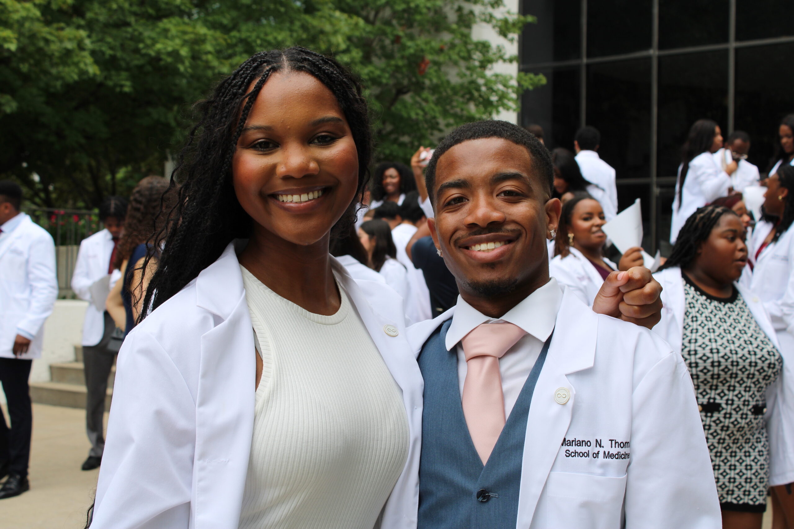 A man and woman in white lab coats posing for a photo.