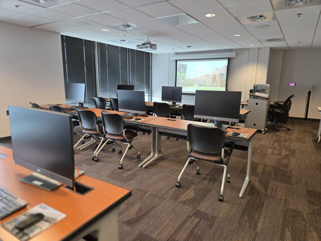 Computer lab with rows of desks and chairs.
