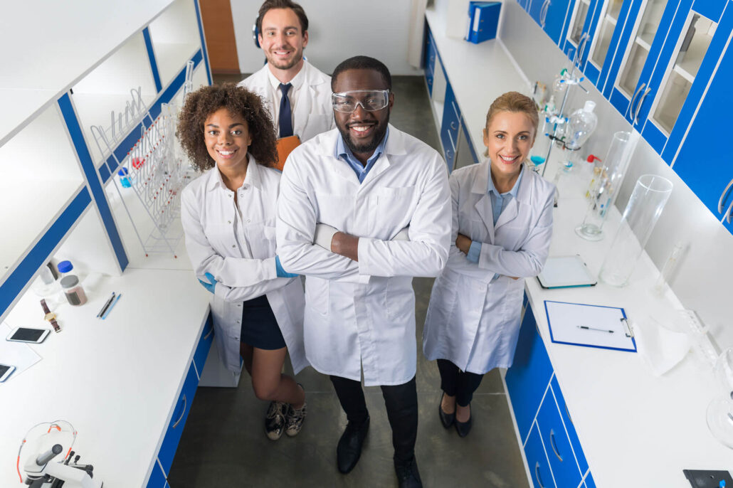 Four people in lab coats standing in a lab.