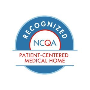 The image is a logo with the text "RECOGNIZED" at the top, followed by "NCOA" and "PATIENT-CENTERED MEDICAL HOME" below it. The logo features a blue circle with a white checkmark inside.