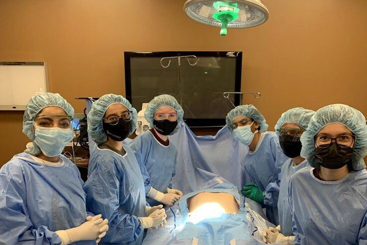 A group of surgeons in a hospital room.