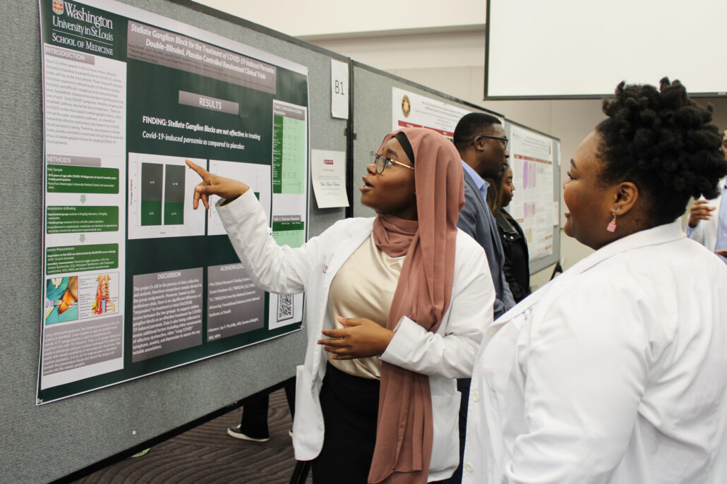 Three people standing in front of a display board.