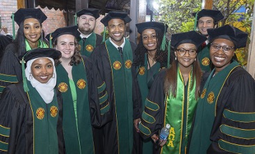 Group of graduates in academic regalia posing for photo.