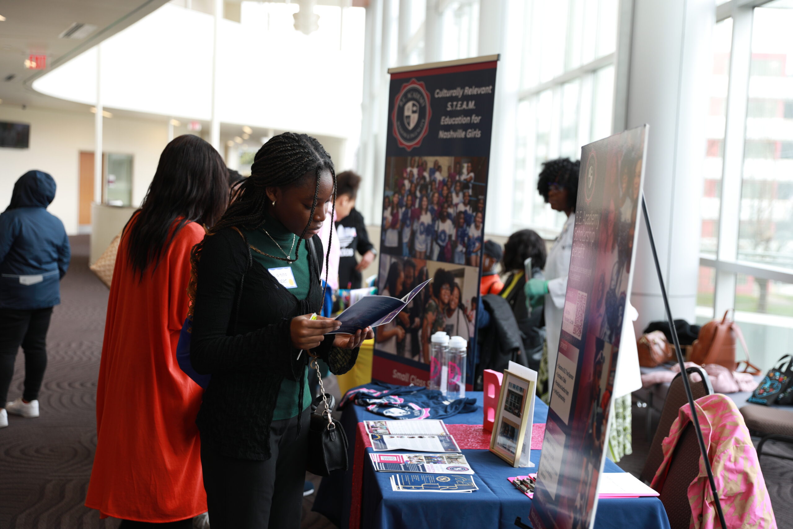 People standing around a table with informational materials.