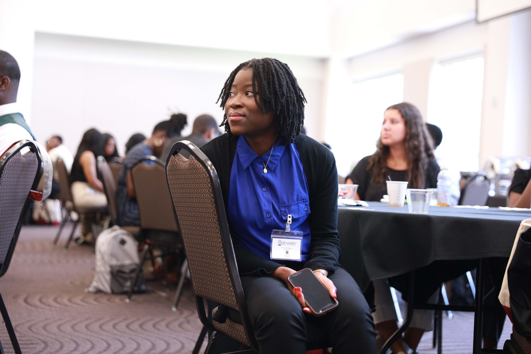 Woman sitting at a table in a conference room.