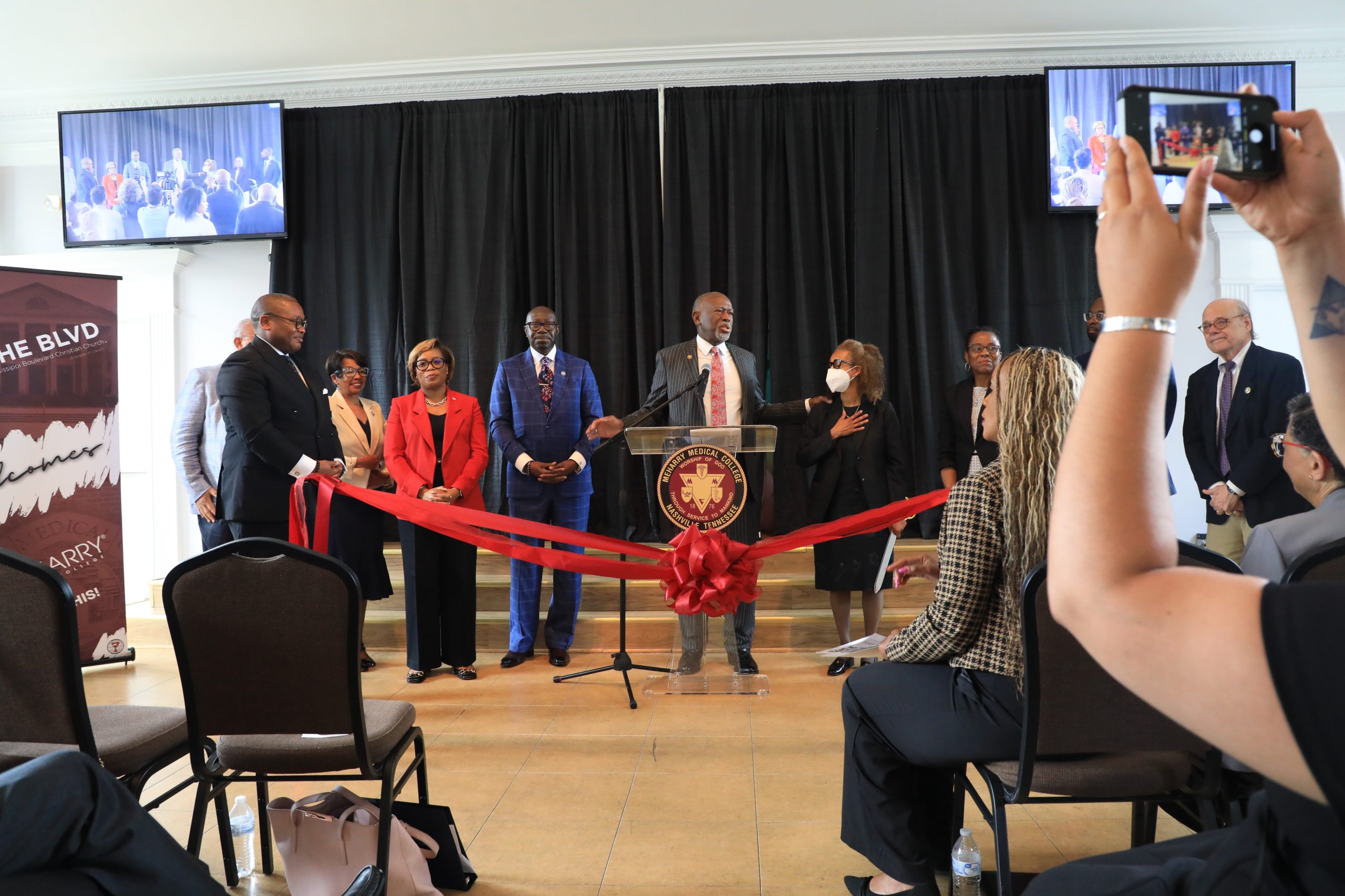 A group of people standing behind a podium at a conference.