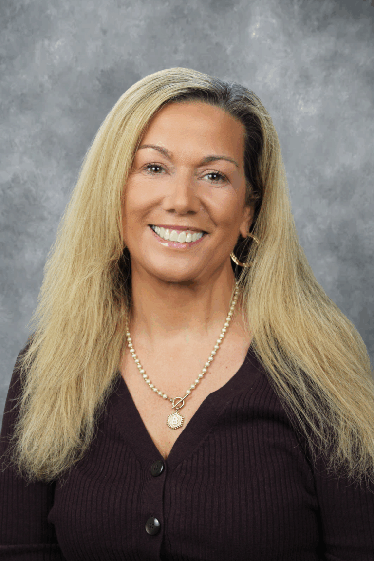 Woman with blonde hair smiling at camera.