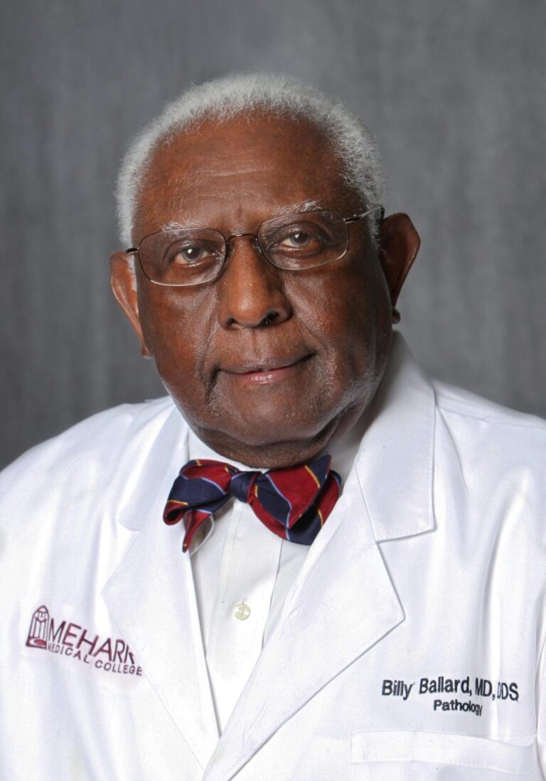 Man in white coat, glasses, and bow tie.