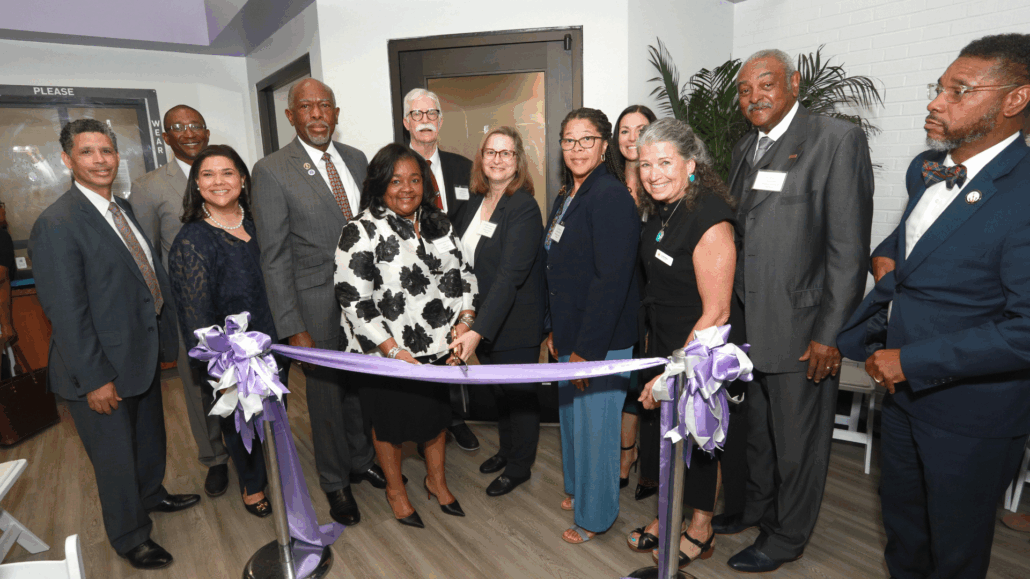 Group of people at a ribbon cutting event.