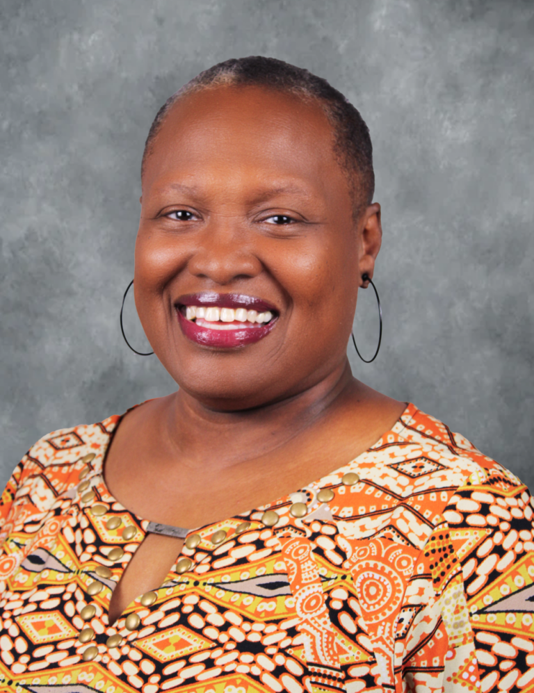 Woman with short hair, smiling, posing for a portrait.