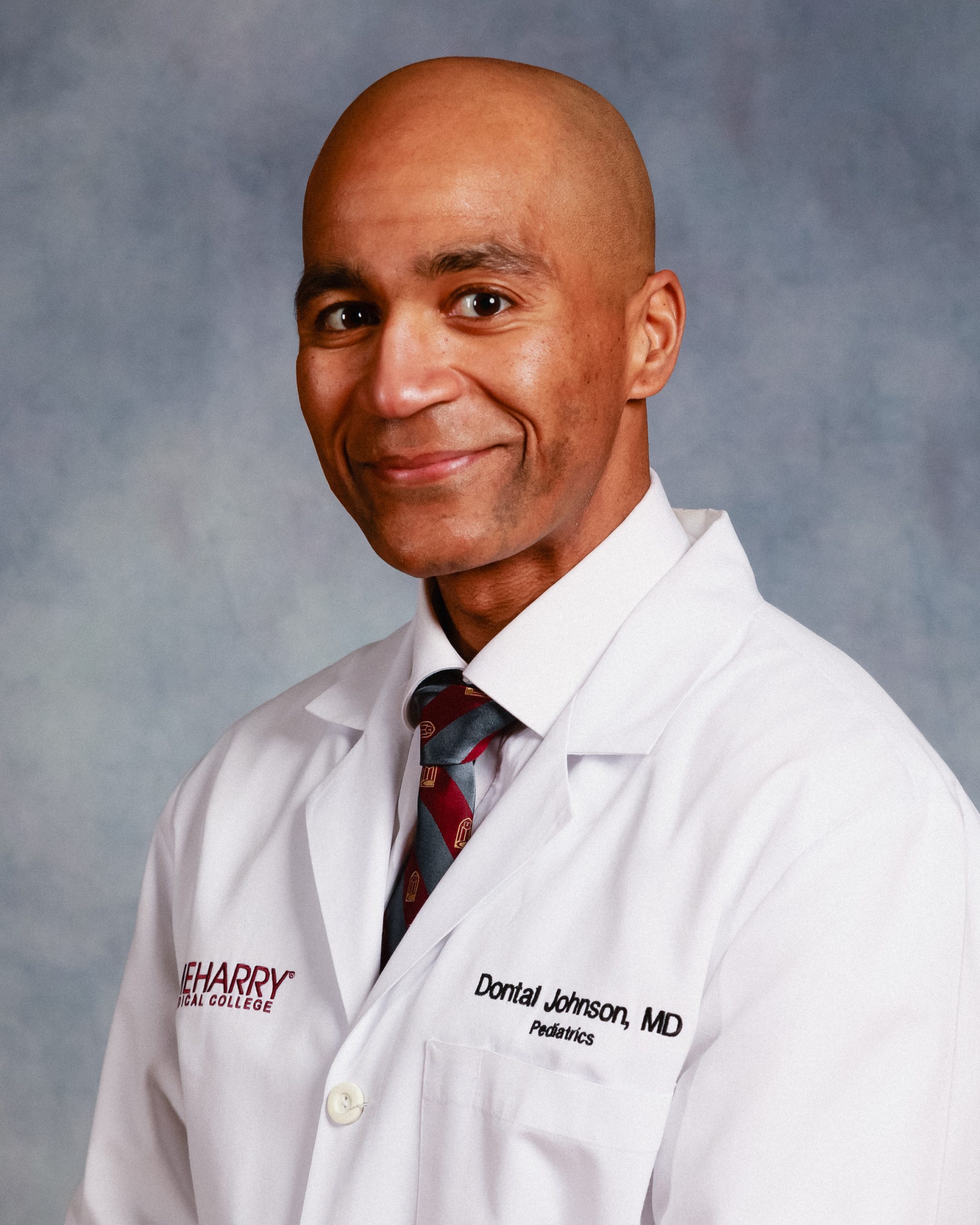 Man in white lab coat posing for portrait.