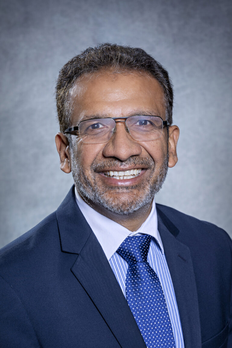 Man in suit smiling at camera.