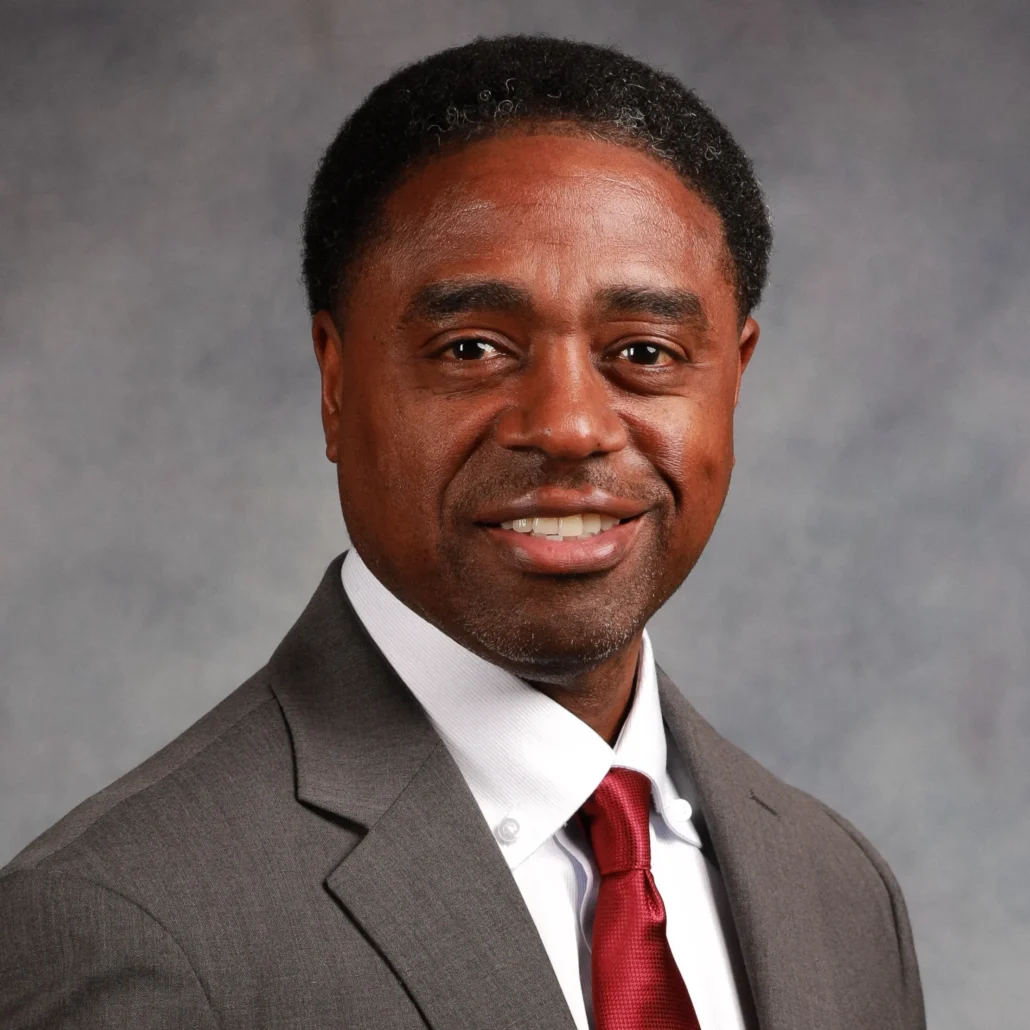 Man in suit standing against wall.