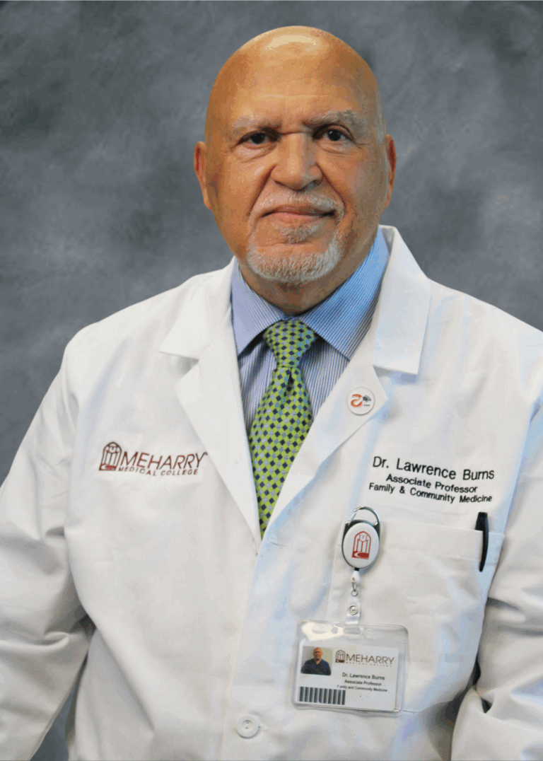 Man in white coat posing for photo.