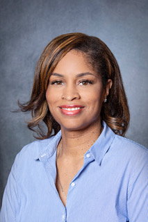 Woman in blue shirt posing for portrait.
