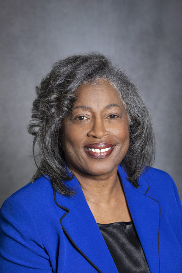 Woman in blue suit posing for portrait.