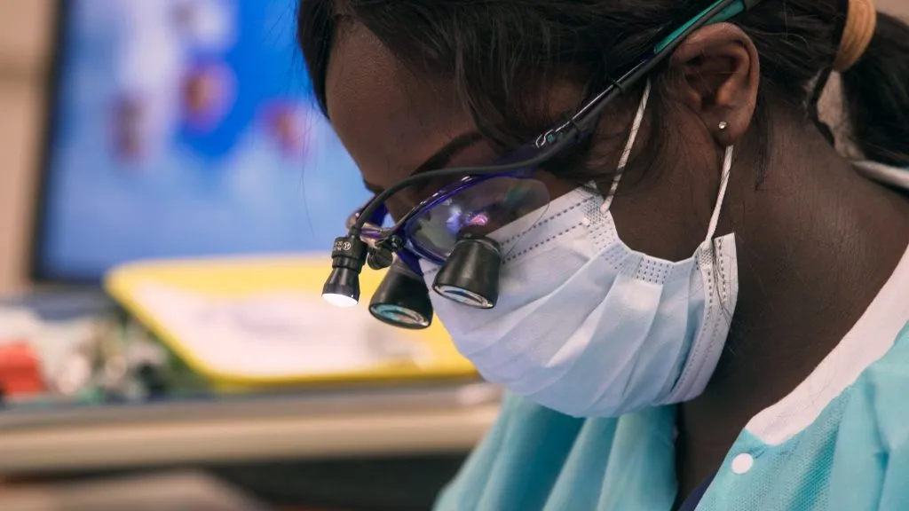 Woman in medical mask working at computer.