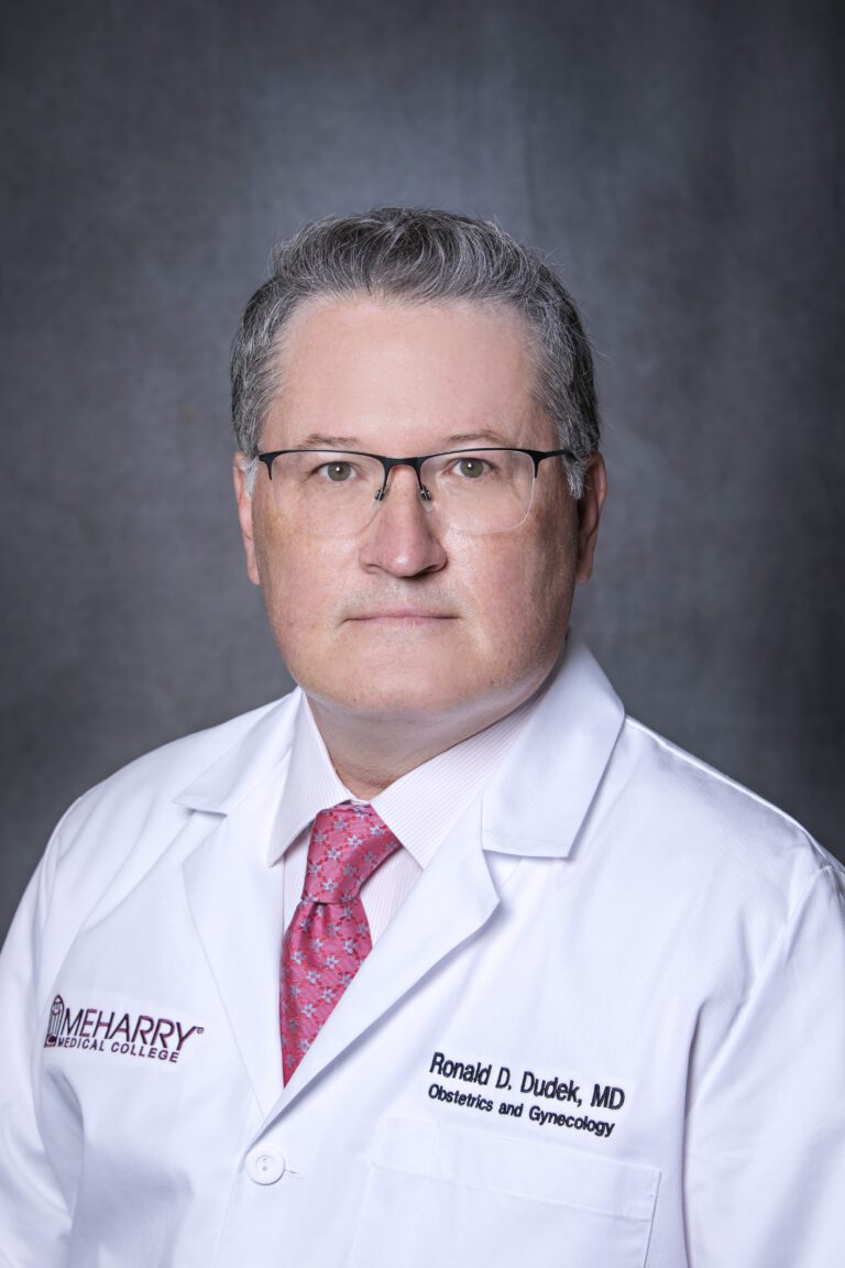 Man in white coat posing for portrait.