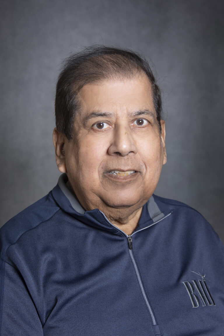 Old man in blue jacket posing for portrait.