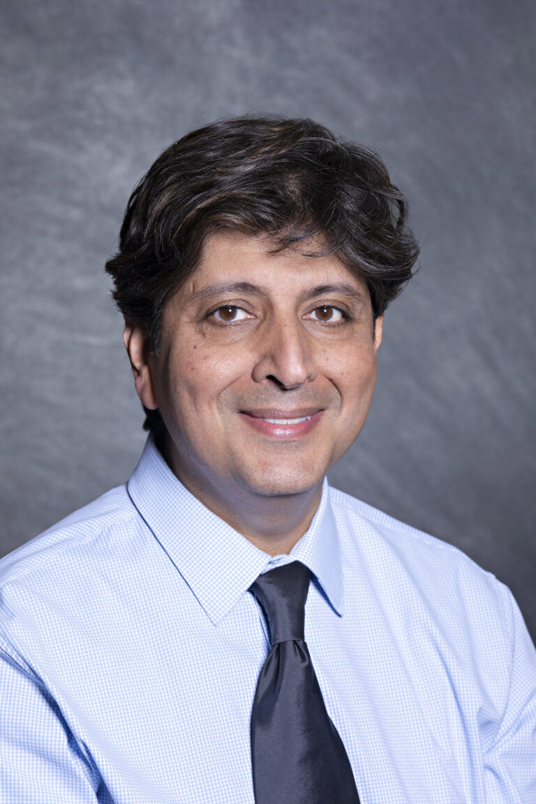 Man in suit smiling at camera.