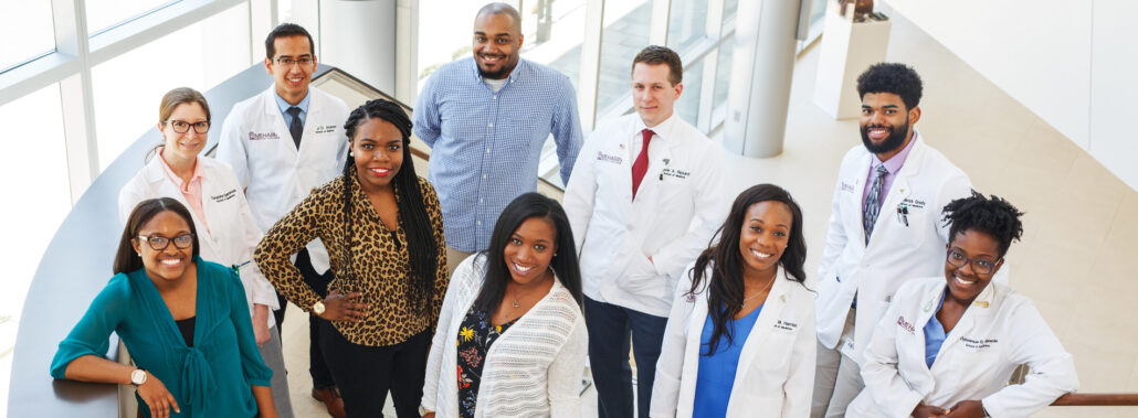 Group of professionals posing for photo in office.