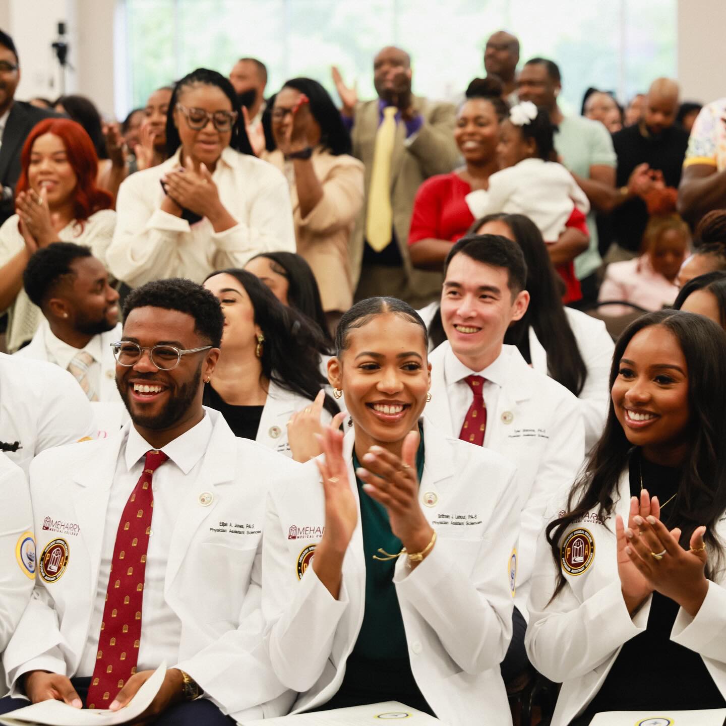 A group of medical professionals celebrating an event, clapping and smiling.