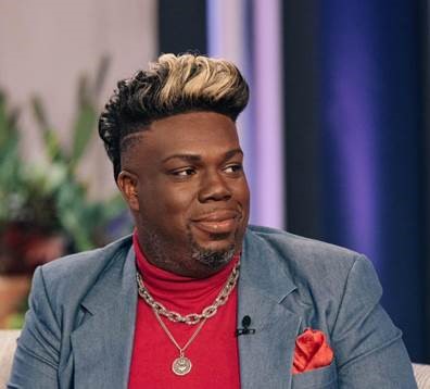 Man in blue suit sitting on a couch.