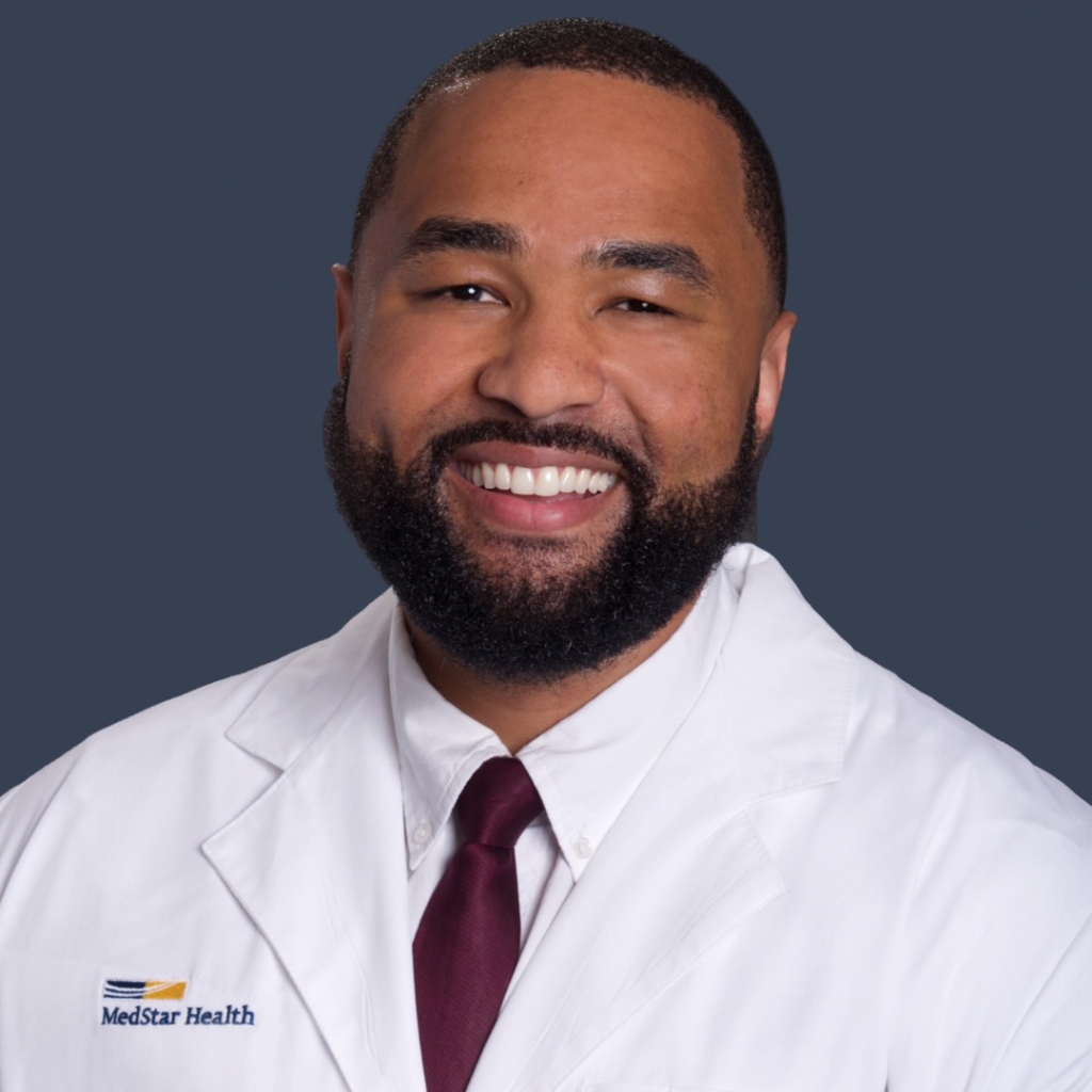 Two men, one smiling, both in white coats, against blue background.