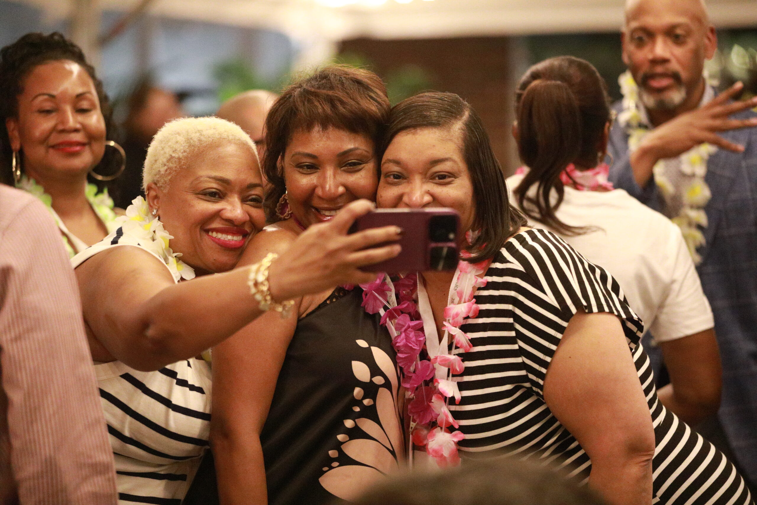 Group of people at a party, smiling and posing for a photo.