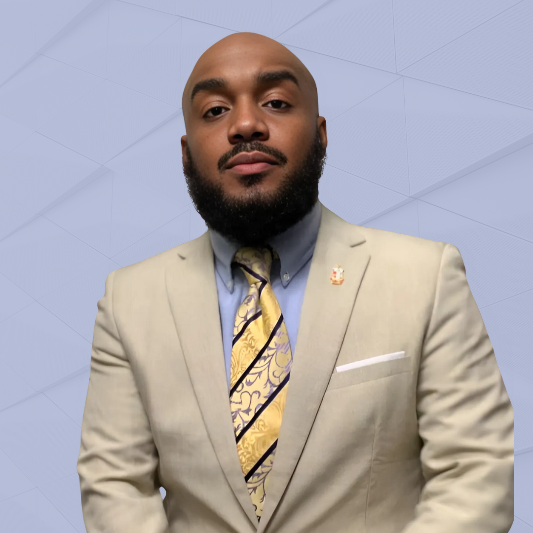 Man in suit standing against blue background.
