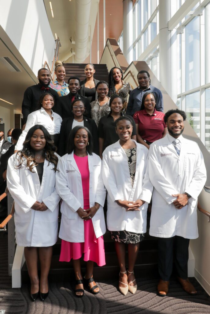 Group of people standing in front of a staircase.