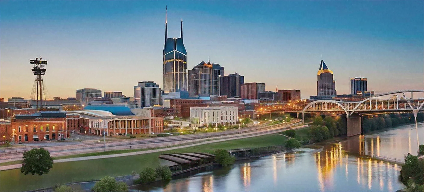 Cityscape at sunset with a bridge over a river.