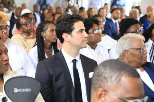 Man in suit standing in front of crowd.