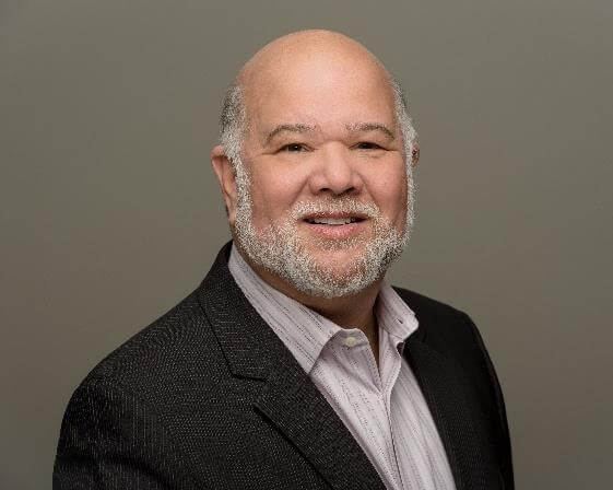 Man in suit smiling at camera.