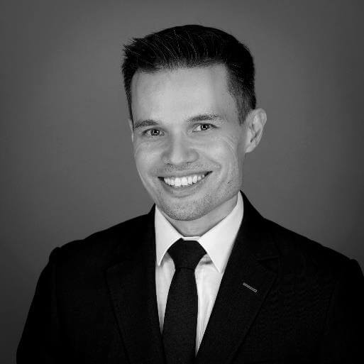 Man in suit smiling at camera.