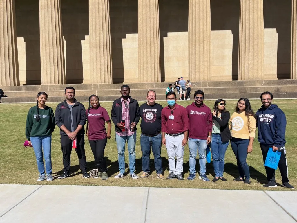 Group of people posing in front of a building.
