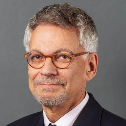 Man in suit with glasses and beard.