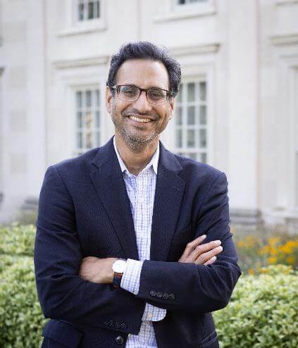 Man in suit standing in front of building.