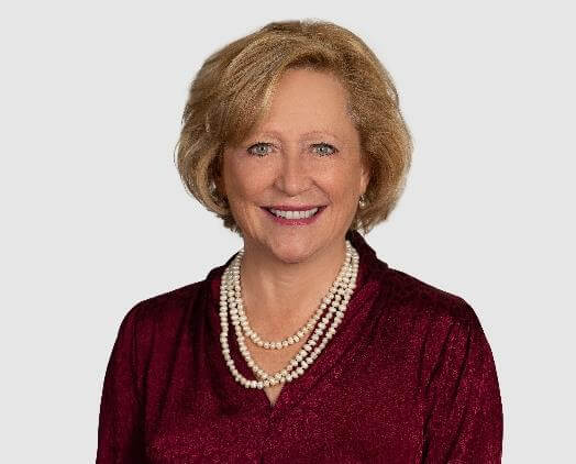 Woman in red shirt, smiling, posing for portrait.