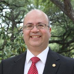 Man in suit smiling at camera.