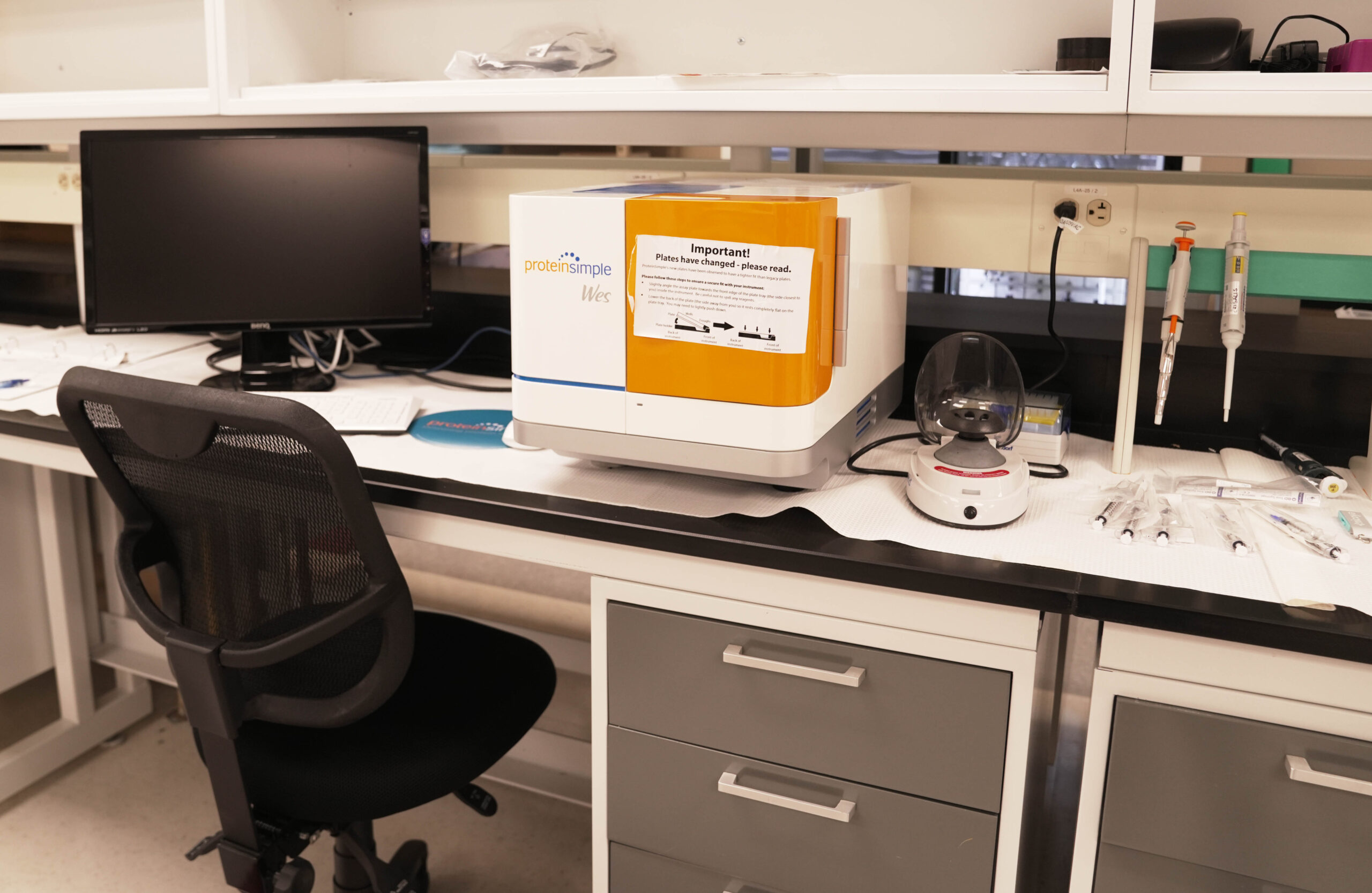 A well-equipped laboratory with a desk, computer, and various scientific equipment.