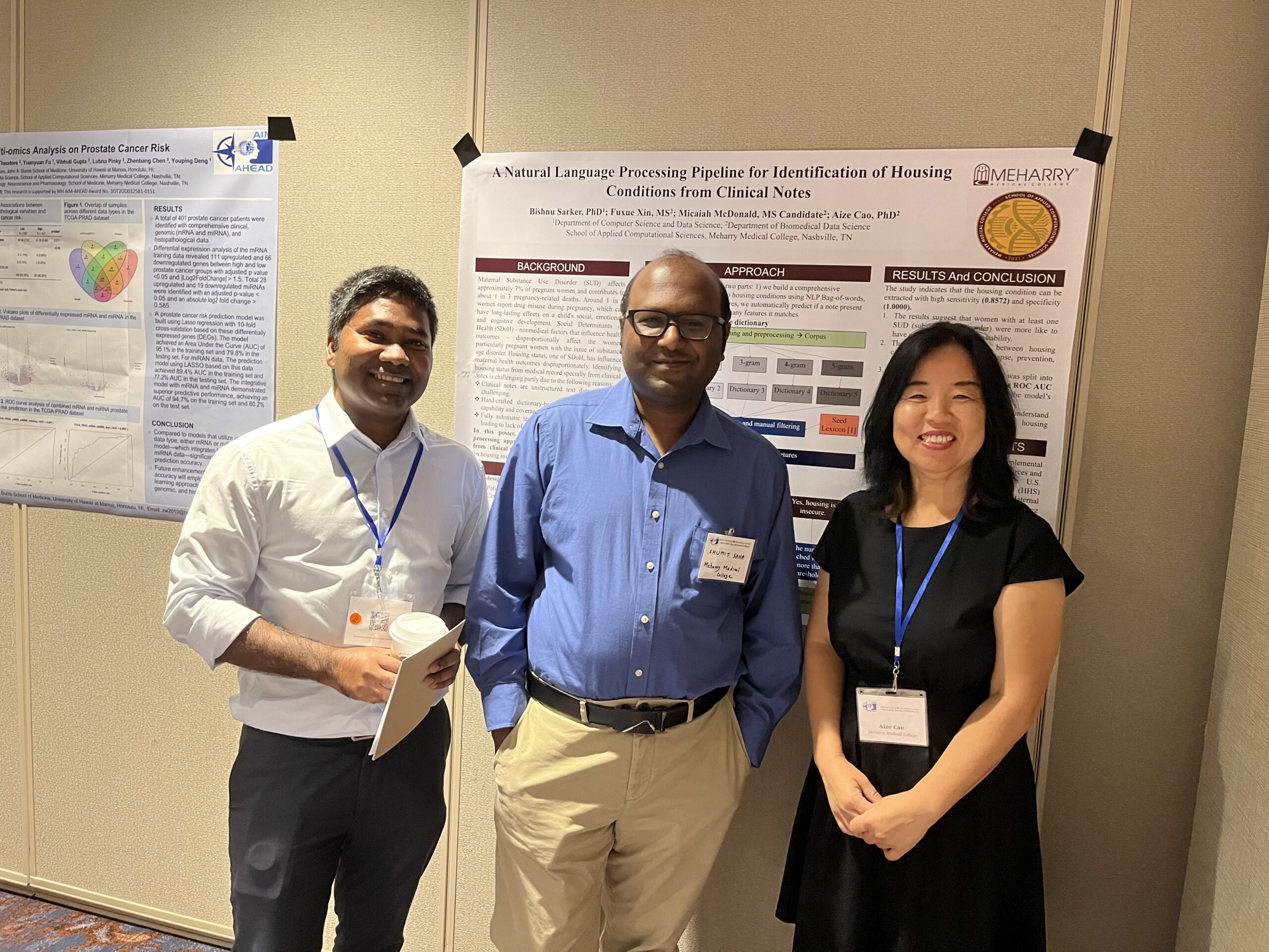 Three people standing in front of a poster board.