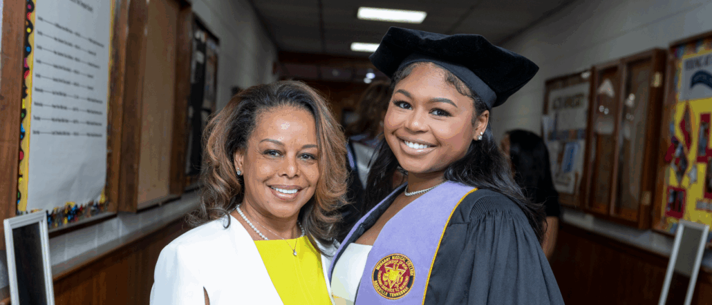 A woman and girl in graduation attire.