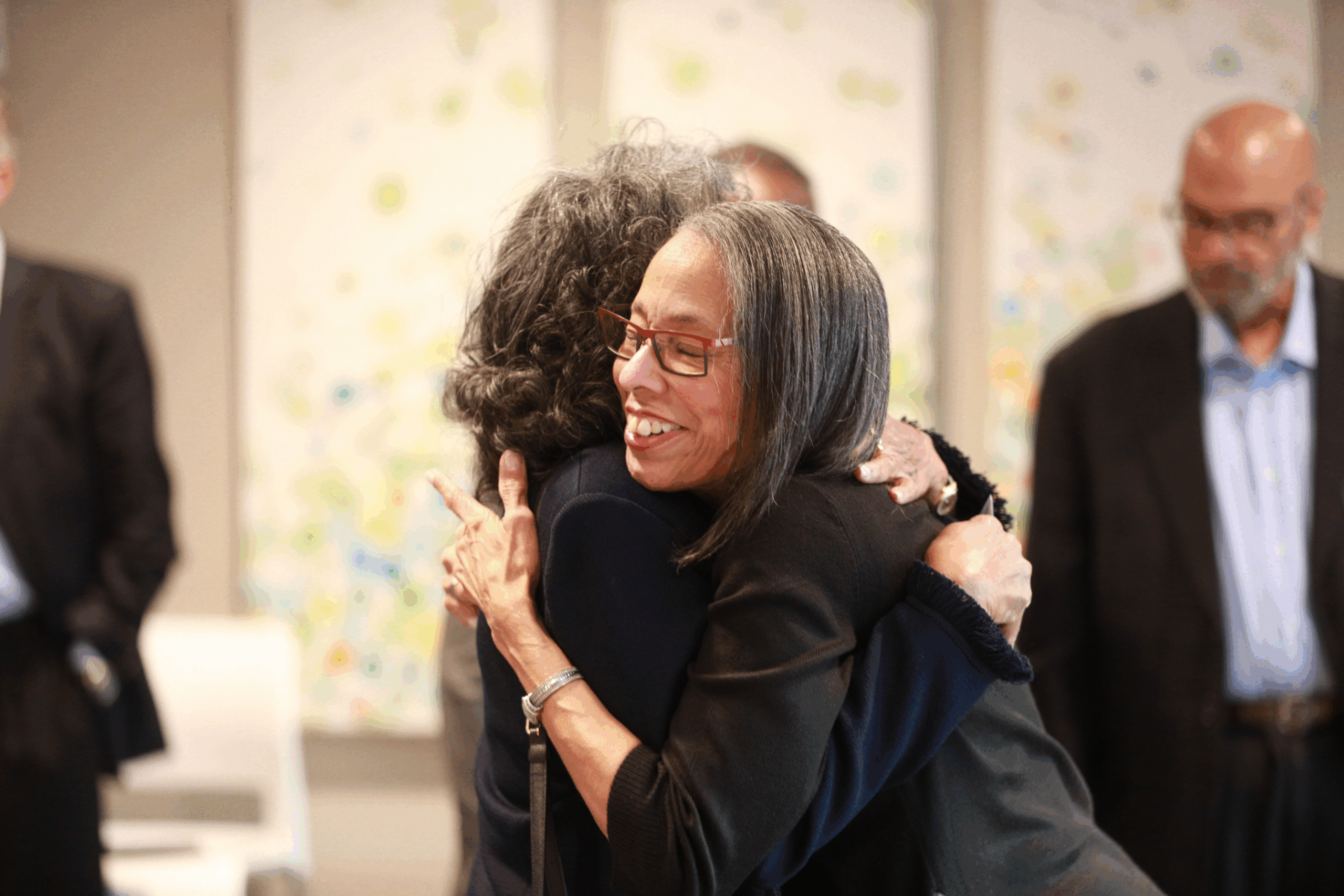 Two women hugging in a room.