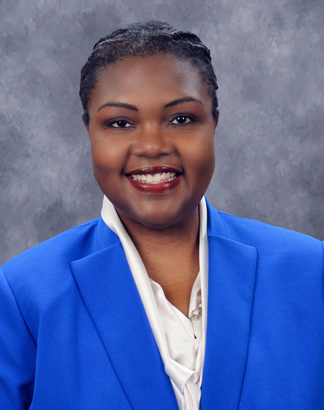 Woman in blue jacket posing for portrait.