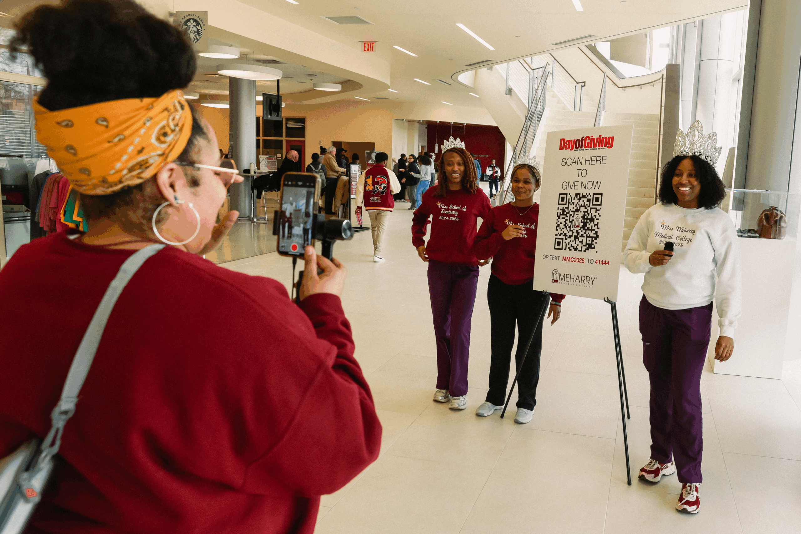 A group of people in a room, with one person taking a photo.